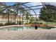 Screened in pool area with water features, poolside loungers, and spacious patio at 3142 Stonegate Falls Dr, Land O Lakes, FL 34638