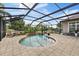 Inviting in-ground pool area surrounded by brick pavers, a screened enclosure, and lounge chairs at 3142 Stonegate Falls Dr, Land O Lakes, FL 34638