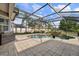 Screened pool area featuring an in-ground pool, brick pavers, built-in grill and lush landscaping at 3142 Stonegate Falls Dr, Land O Lakes, FL 34638