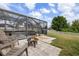 Relaxing screened-in pool area with fire pit, comfortable seating, and lush lawn at 3142 Stonegate Falls Dr, Land O Lakes, FL 34638