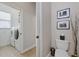 Compact half-bath with a toilet, decorative art, and a laundry room view at 3142 Stonegate Falls Dr, Land O Lakes, FL 34638