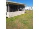 A patch of green grass extends to the exterior of the home's screened-in porch at 361 Fairhaven St, Port Charlotte, FL 33952