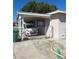 View of the carport with a white car behind a chain-link fence under a bright blue sky at 361 Fairhaven St, Port Charlotte, FL 33952