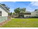 Large backyard featuring green grass, a screened in porch, and a detached garage for outdoor activities at 3711 W Dale Ave, Tampa, FL 33609