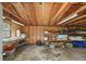 Unfinished garage with exposed rafters, concrete floors, storage shelves, and a side window at 3711 W Dale Ave, Tampa, FL 33609