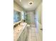 Elegant bathroom with white cabinets, marble countertop, subway tile shower, white flooring, and great lighting at 425 E Orange St, Tarpon Springs, FL 34689