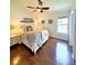 Inviting bedroom featuring a ceiling fan, hardwood floors, a cozy bed, bedside tables, and a bright window at 425 E Orange St, Tarpon Springs, FL 34689