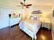 Bright bedroom features an overhead fan, hardwood floors, a cozy bed, side tables, and a dresser at 425 E Orange St, Tarpon Springs, FL 34689