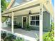 Charming home exterior featuring a spacious front porch with ceiling fans and lovely landscaping at 425 E Orange St, Tarpon Springs, FL 34689