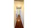 Well-lit hallway features wood flooring, neutral walls, and doors to the bedrooms and other rooms at 425 E Orange St, Tarpon Springs, FL 34689