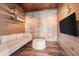 Finished basement featuring a brick accent wall, wood paneling, and stylish decor at 4354 Barletta Ct, Wesley Chapel, FL 33543