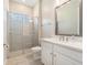 Bright bathroom featuring a glass shower, white vanity, and a large mirror at 4354 Barletta Ct, Wesley Chapel, FL 33543