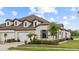 Beautiful home exterior featuring stone accents, a well-manicured lawn, and a three-car garage at 4354 Barletta Ct, Wesley Chapel, FL 33543