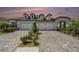 Charming three-car garage home featuring stone accents and brick paved driveway at 4354 Barletta Ct, Wesley Chapel, FL 33543