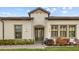 Home exterior displaying covered front entrance with dark trim windows and neutral paint at 4354 Barletta Ct, Wesley Chapel, FL 33543