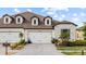 Home exterior displaying a three car garage and driveway with manicured landscaping at 4354 Barletta Ct, Wesley Chapel, FL 33543