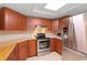 Modern kitchen boasts stainless steel appliances, wooden cabinetry, and ample counter space at 4414 Plumosa St, Spring Hill, FL 34607