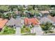 Aerial view of a home with a clay tile roof, screened-in pool, a well-manicured front yard at 4847 Harbor Woods Dr, Palm Harbor, FL 34683