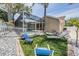 Outdoor living area with turf, lounge seating, and screened in pool at 4847 Harbor Woods Dr, Palm Harbor, FL 34683