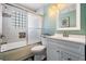 Bathroom with tub, glass shower door, tile surround, and vanity at 4847 Harbor Woods Dr, Palm Harbor, FL 34683