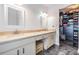 Bathroom with double sinks, framed mirrors, and walk-in closet at 4847 Harbor Woods Dr, Palm Harbor, FL 34683
