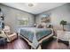 This is a cozy bedroom features a queen bed, wood floors, and a comfortable reading chair at 4847 Harbor Woods Dr, Palm Harbor, FL 34683