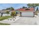 Charming one-story home featuring a two-car garage and attractive landscaping with flowers and palm trees at 4847 Harbor Woods Dr, Palm Harbor, FL 34683