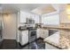 Well-lit kitchen showcases granite countertops, stainless steel appliances, white cabinetry, and epoxy floors at 4847 Harbor Woods Dr, Palm Harbor, FL 34683
