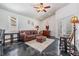 Living room with high ceilings, ceiling fan, leather sofa, and black marble-style flooring at 4847 Harbor Woods Dr, Palm Harbor, FL 34683