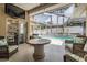 Outdoor patio area featuring a table and chairs with views of the screened-in pool and backyard at 4847 Harbor Woods Dr, Palm Harbor, FL 34683