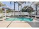Inviting screened-in pool with a kidney shape, complemented by hanging plants and a white fence at 4847 Harbor Woods Dr, Palm Harbor, FL 34683