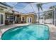 Swimming pool with tropical landscaping, covered patio and seating at 4847 Harbor Woods Dr, Palm Harbor, FL 34683