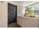 Close-up of the front door to unit 4917 with a black door, a decorative peephole, and a potted plant at 4917 Puritan Cir # 105, Tampa, FL 33617