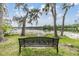 A peaceful lake view with a park bench overlooking the calm water and trees in the background at 4917 Puritan Cir # 105, Tampa, FL 33617