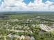 An aerial view of a large neighborhood with lush green trees, waterways, and scattered clouds above on a sunny day at 6116 Skylarkcrest Dr, Lithia, FL 33547