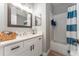 Well-lit bathroom with a vanity, large mirror, and a shower-tub combo featuring a bright blue shower curtain at 6116 Skylarkcrest Dr, Lithia, FL 33547