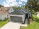 Charming single-story home features a well-manicured lawn, a gray roof and a gray two-car garage at 6116 Skylarkcrest Dr, Lithia, FL 33547