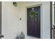 Inviting front door featuring a dark color, decorative wreath, stylish lantern, and textured walls at 6116 Skylarkcrest Dr, Lithia, FL 33547