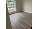 Cozy bedroom showcasing wood grain vinyl floors and large windows, perfect for natural light at 613 Coronet St, Plant City, FL 33563