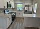Modern kitchen featuring stainless steel appliances, quartz countertops and wood grain vinyl floors at 613 Coronet St, Plant City, FL 33563