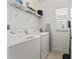 Well-lit laundry room with a washer and dryer and overhead shelving at 6731 Rocky Park St, Tampa, FL 33625