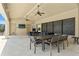 Outdoor seating area with ceiling fans, outdoor table and chairs, and a large screen television at 6731 Rocky Park St, Tampa, FL 33625