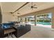 A covered outdoor seating area with ceiling fans overlooks a beautiful pool surrounded by lush landscaping at 6731 Rocky Park St, Tampa, FL 33625