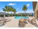 Community pool with lounge chairs under blue sky with palm trees, and well manicured landscaping at 6731 Rocky Park St, Tampa, FL 33625