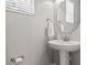 Bright powder room featuring a round mirror and white pedestal sink at 6731 Rocky Park St, Tampa, FL 33625