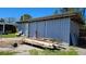 Exterior shot of backyard, showing the outbuilding, door, a small lawn and some supplies at 6904 11Th Ave E, Palmetto, FL 34221