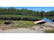 Scenic backyard view with a fire pit, canoe, green grass, lush greenery, and a nearby waterway at 6904 11Th Ave E, Palmetto, FL 34221