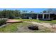A view of the backyard features the house, a firepit, a canoe, some seating and green grass at 6904 11Th Ave E, Palmetto, FL 34221