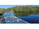 A wooden dock with rope railing overlooks a serene body of water surrounded by lush green vegetation at 6904 11Th Ave E, Palmetto, FL 34221