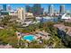 An aerial view of waterfront buildings, a pool, and lush greenery showcases the community's amenities at 716 Seagate Dr # 716, Tampa, FL 33602